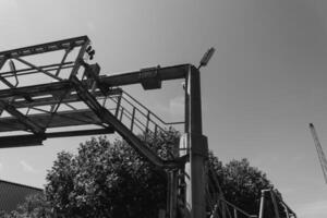 Sturdy construction framework rises against a bright sky while a crane looms in the background during a sunny afternoon photo