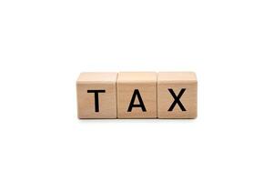 TAX Word with Wooden Blocks on White Background with clipping path. taxation, financial obligations, and accounting concepts, and is ideal for conveying topics related to business, finance. photo