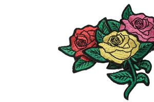 Horizontal embroidery of three roses in yellow, pink, and red, placed on the right side against a clean white background with text space on the left. Perfect romantic design for weddings and love. photo