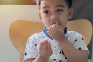 Portrait image of small Asian child, boy 3 years old wants to eat gelatinous sweets. photo