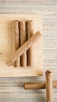 Top view of delicious chocolate wafer roll on a wooden board isolated on wooden textured background photo