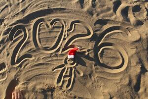 2026 and Santa Claus Hat on the Sand photo
