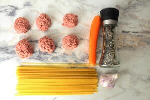 Concept of the recipe for cooking meatballs with spaghetti pasta view from above photo