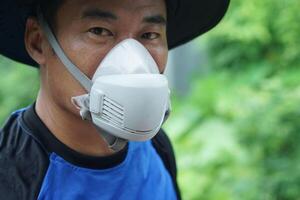 A protective face mask used by farmer during pesticide or chemical spraying. The mask helps prevent inhalation of toxic substances. Concept safety and health in agricultural environments. photo