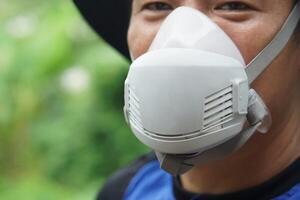 Close-up of protective face mask used by farmer during pesticide or chemical spraying. The mask helps prevent inhalation of toxic substances. Concept safety and health in agricultural environments. photo