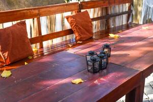Wooden table and bench for celebrating a holiday, with autumn colors decor, macrame and garland photo