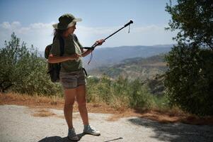 Hiker Exploring Scenic Trail with Backpack and Trekking Pole Under Sunny Weather photo
