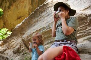 Mother and Child Enjoying a Peaceful Break Amidst a Rocky Cliff During a Nature Excursion photo
