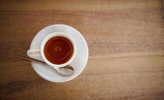 White Cup of Espresso on Wooden Table with a Spoon photo
