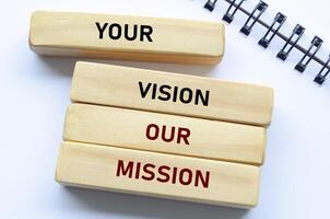 Your vision our mission text on wooden blocks and notebook emphasizes alignment with client goals and shared purpose photo