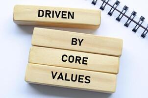 Driven by core values text on wooden blocks and notebook represents purposeful direction guided by foundational beliefs photo