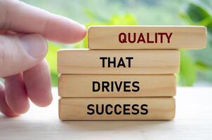 Quality that drives success text on wooden blocks being pushed forward symbolizes how excellence leads to real achievement photo