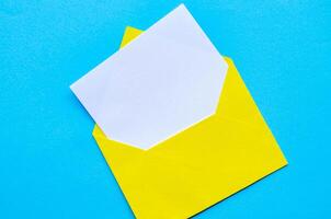 Top view of white notepad with envelope on blue cover background with customizable space for text or ideas. photo