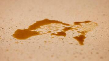 A hand uses a blue cloth to clean a coffee spill on a speckled countertop under warm lighting video