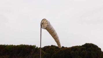 A windsock sways gently against a cloudy sky at Port Campbell, capturing the serene coastal atmosphere video