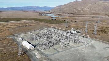 Drone footage captures an expansive power substation in Lake Tekapo, New Zealand, surrounded by rugged landscapes under clear skies video