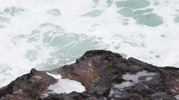 Dynamic ocean waves crash against rugged rocks, captured in bright daylight along Australia's Great Ocean Road video