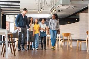 Diverse Group of Kids and Adults Walking Through a Modern Office Space, Mentors Guiding Young Students on a Tour of a Workplace, Happy Children Learning and Exploring in a Professional Environment photo