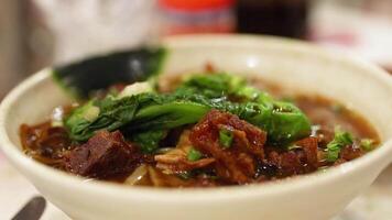 Chopsticks lifting meat from noodle soup video
