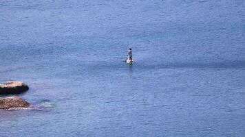 Person paddleboarding near rocky shore in Phuket video