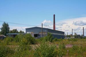 An abandoned factory now stands, surrounded entirely by thriving nature and greenery photo