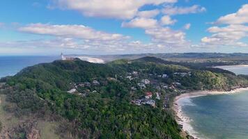 Drone footage captures the scenic coastline and iconic lighthouse at Byron Bay, Australia, under clear skies with vibrant ocean views video
