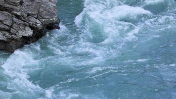 Dynamic river rapids cascade over rocky cliffs in Queenstown, New Zealand, captured with natural lighting and steady camera work video