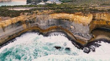 Drone captures dramatic waves crashing against the eroded cliffs of Port Campbell, Australia, highlighting natural beauty and geological formations video