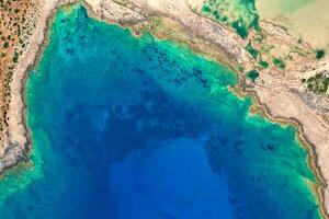 Vibrant waters and rugged beach rocks on the west side of Crete photo