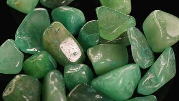 A close-up view of polished green aventurine stones with subtle lighting changes over 11 seconds video