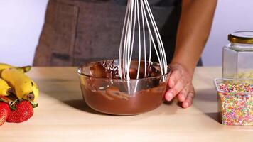 Mixing chocolate with bananas and strawberries nearby video