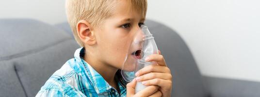 Treatment at home of a toddler. A boy is using nebuliser. photo