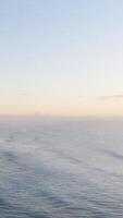 Calm ocean waves under a soft sunrise sky at Gold Coast, Australia. Gentle camera movement captures the tranquil seascape video