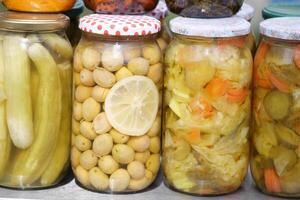 Colorful jars of preserved fruits and vegetables on display photo