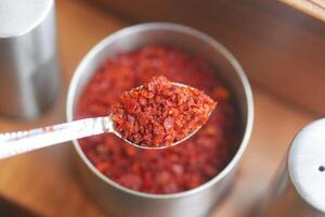 Red chili flakes add flavor to dishes at mealtime photo