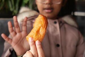 Child enjoys a crispy treat at a local eatery in winter photo