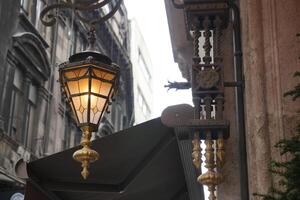 Vintage street lamp illuminated in urban setting photo