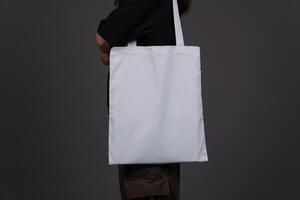 Side View of Woman Holding Blank Canvas Tote Bag, Eco-Friendly Reusable Fabric with Handle, Close-Up Mockup, No Plastic and Environmental Concept Isolated Background photo