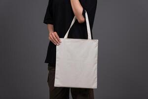 Front View of Female Holding Blank Canvas Tote Bag, Eco-Friendly Reusable Fabric with Handle, Close-Up Mockup, No Plastic and Environmental Concept photo