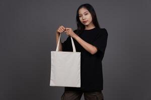 Front View of Woman Holding Blank Canvas Tote Bag, Eco-Friendly Reusable Fabric with Handle, Close-Up Mockup, No Plastic and Environmental Concept And Shopping photo