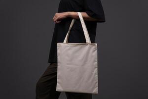 Side View of Woman Holding Blank Canvas Tote Bag, Eco-Friendly Reusable Fabric with Handle, Close-Up Mockup, No Plastic and Environmental Concept Isolated photo