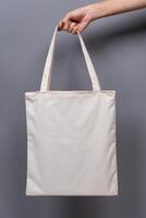 Female Hand Holding Blank Canvas Tote Bag, Eco-Friendly Reusable Fabric with Handle, Close-Up Mockup, No Plastic and Environmental Concept Isolated Background photo