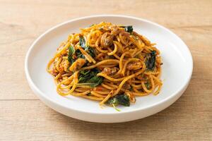 Stir Fried Spaghetti with Clam and Chilli Paste - Fusion food style on wooden background photo