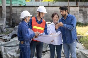 Newly wed couple is meeting with engineering contractor team at their under construction house to inspect the building progress and quality control for home ownership and real estate development photo