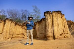 Geologist is exploring and surveying sample rock on the natural sandstone canyon quarry resource site for scientific research and archeology for understanding mother earth photo