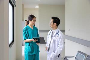 Team of Asian doctor is discussing and brainstorming on patient medical record after diagnosis for precise care plan with experience senior physician specialist photo