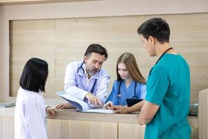 Team of diversity doctor and nurse is discussing and brainstorming over patient medical record after diagnosis for precise care plan with experience senior physician specialist photo