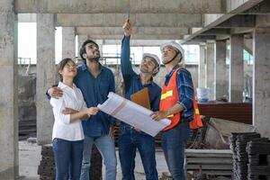 Newly married couple is meeting with engineering contractor at their under construction house to inspect the building progress and quality control for home ownership and real estate development photo