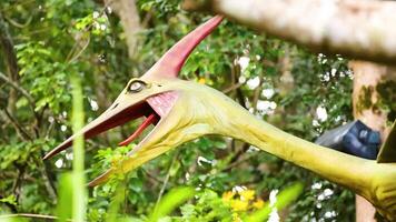A vibrant Pteranodon sculpture in a lush, green environment with dynamic lighting and natural surroundings video