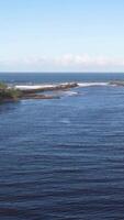 Aerial footage captures the serene coastline of Brunswick Heads, showcasing calm waters and clear skies in a tranquil setting video